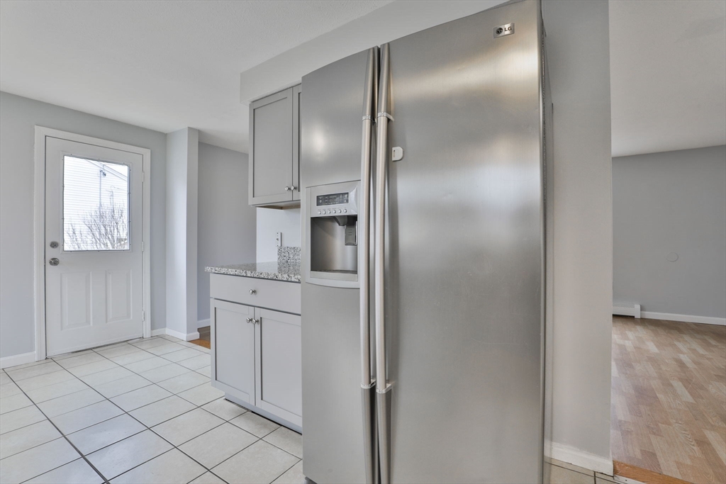 5 Norman Drive, Unit R Derry, NH 03038 - Photo 12 of 28 a kitchen with white cabinets and stainless steel appliances