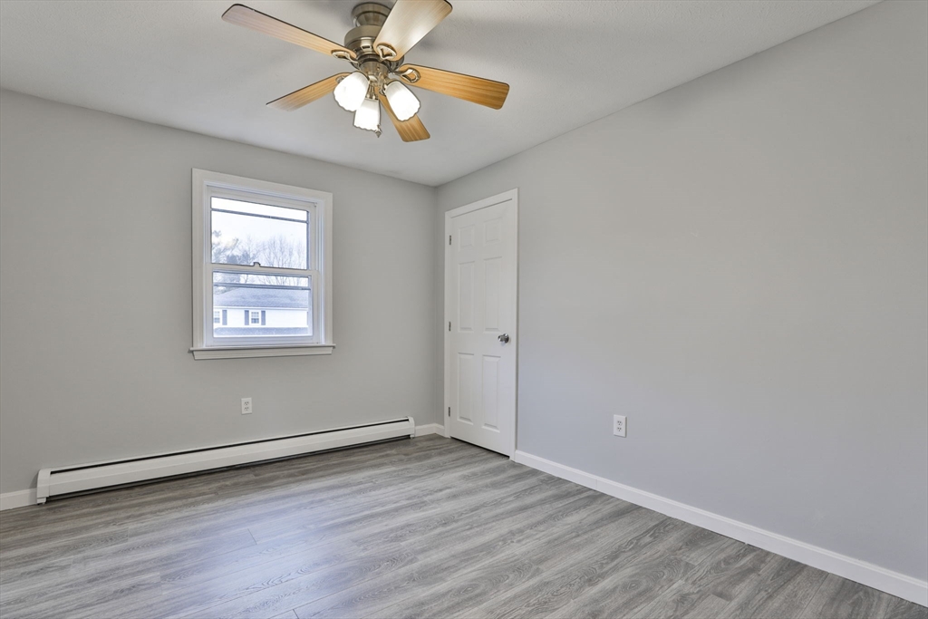 5 Norman Drive, Unit R Derry, NH 03038 - Photo 17 of 28 an empty room with wooden floor chandelier fan and windows