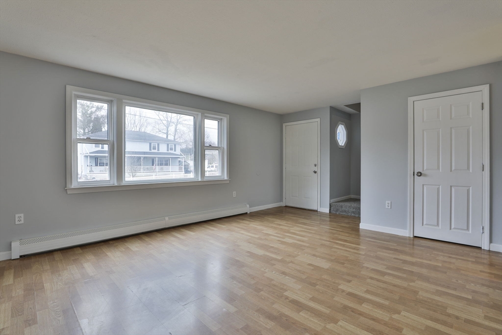 5 Norman Drive, Unit R Derry, NH 03038 - Photo 2 of 28 an empty room with wooden floor and windows
