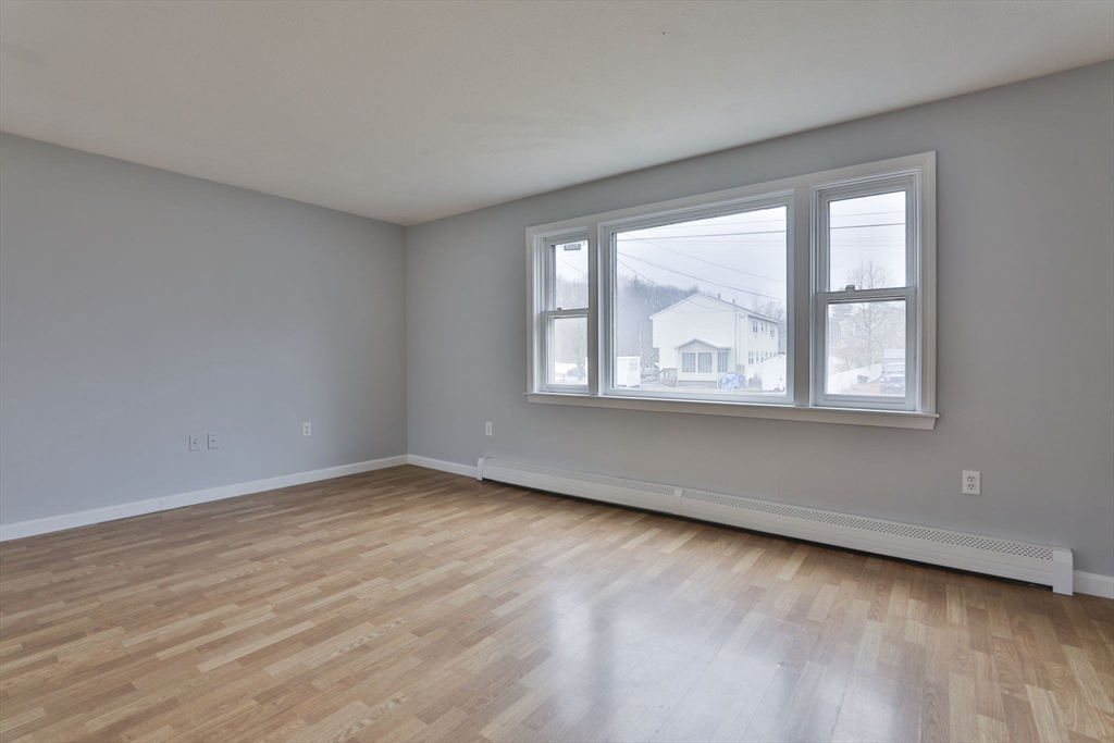 5 Norman Drive, Unit R Derry, NH 03038 - Photo 3 of 28 a view of an empty room with wooden floor and a window