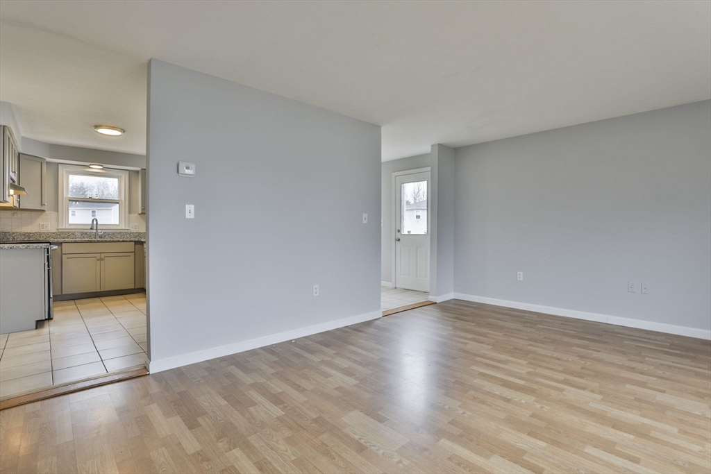 5 Norman Drive, Unit R Derry, NH 03038 - Photo 5 of 28 wooden floor in an empty room with a kitchen