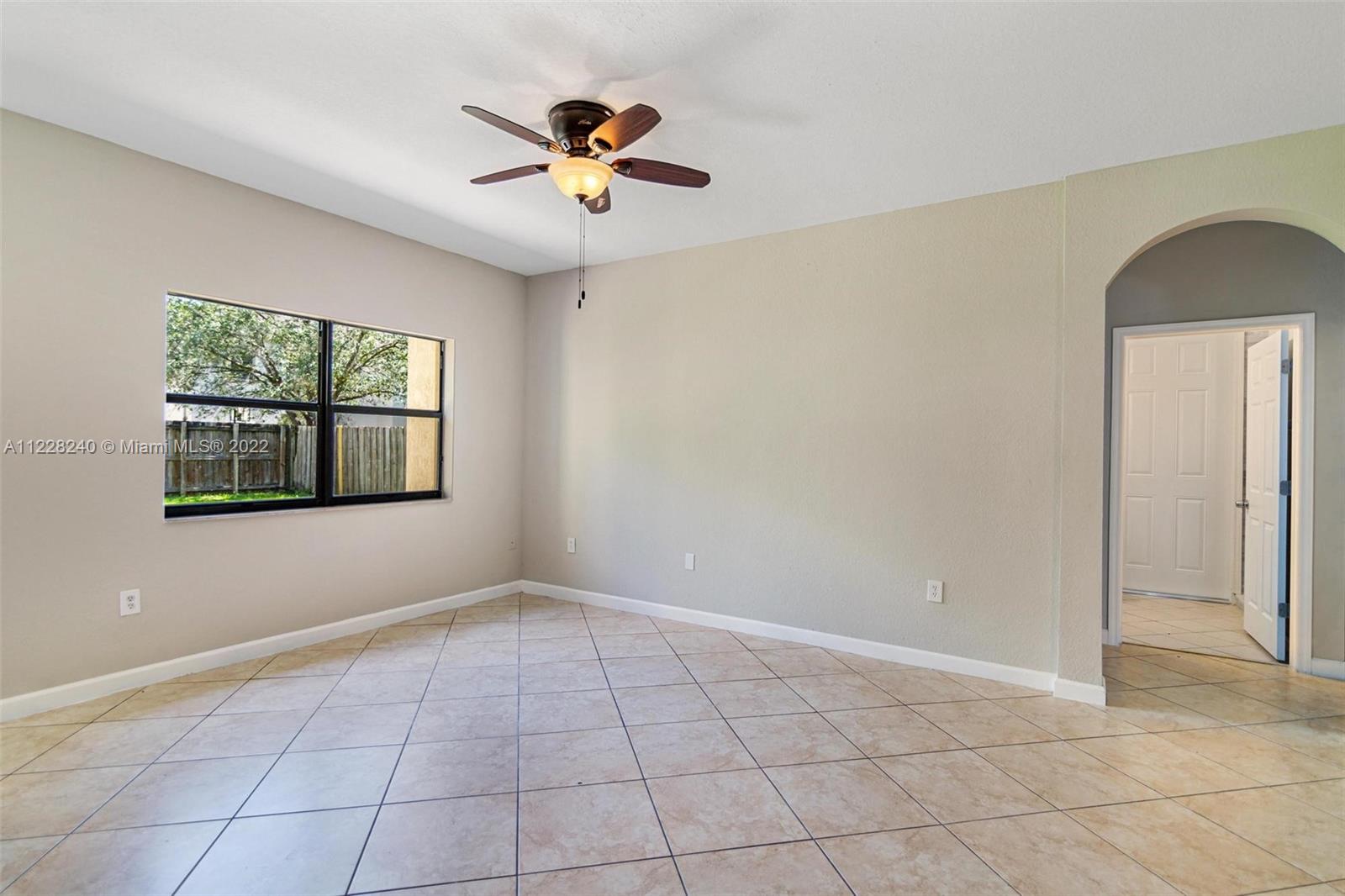 11451 Southwest 243 Terrace Homestead, FL 33032 - Photo 11 of 49 an empty room with windows and chandelier fan