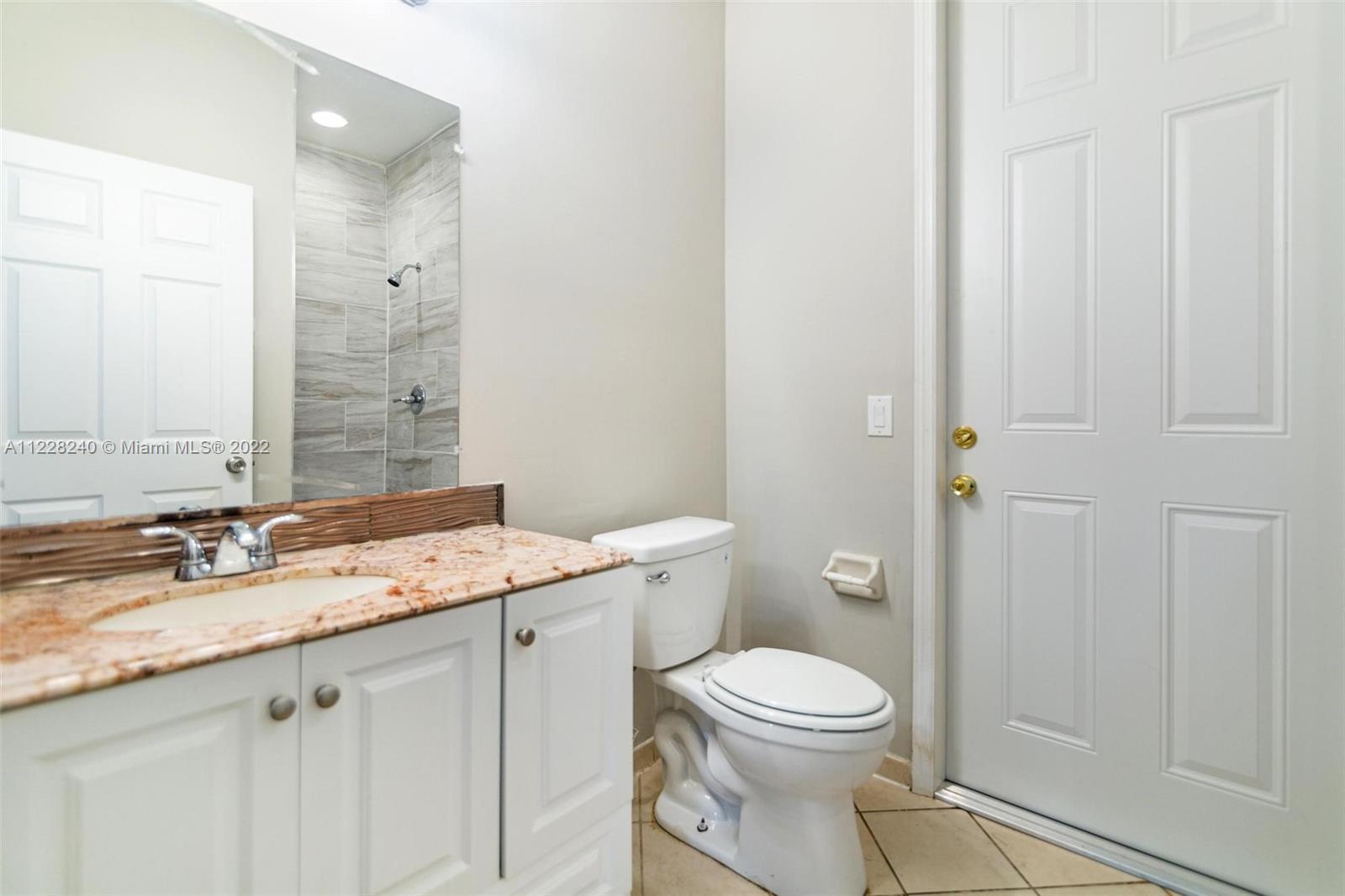 11451 Southwest 243 Terrace Homestead, FL 33032 - Photo 12 of 49 a bathroom with a granite countertop toilet a sink and a mirror