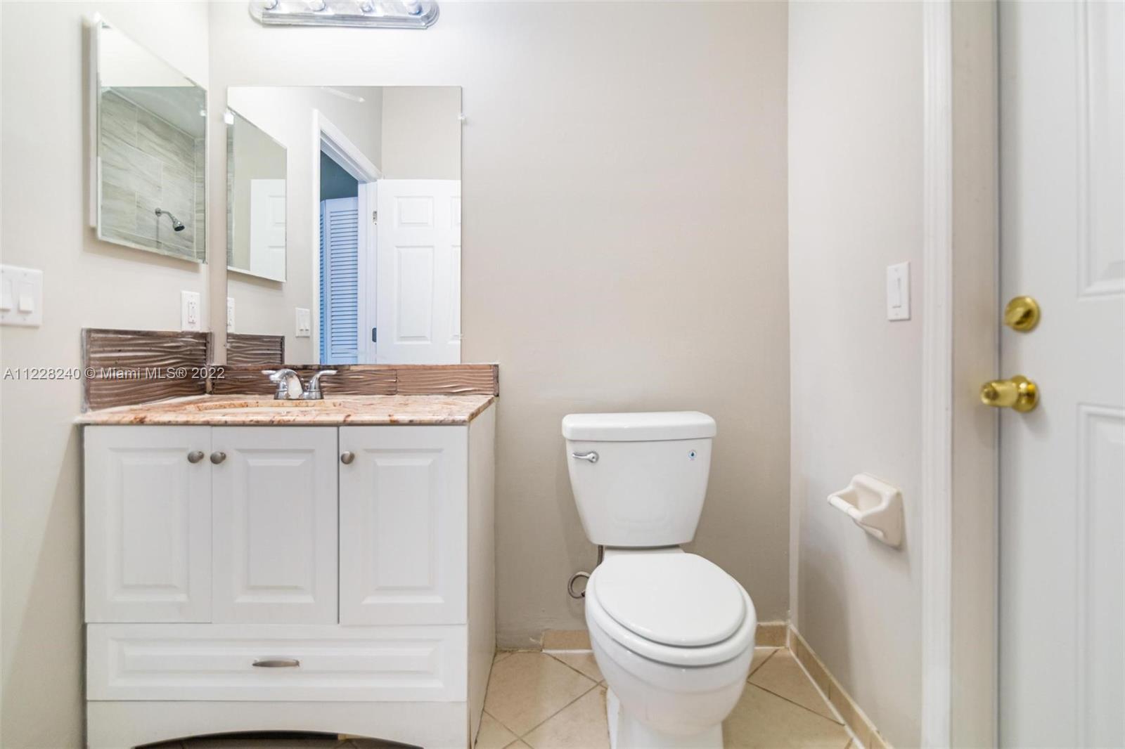 11451 Southwest 243 Terrace Homestead, FL 33032 - Photo 14 of 49 a bathroom with a granite countertop toilet sink and mirror