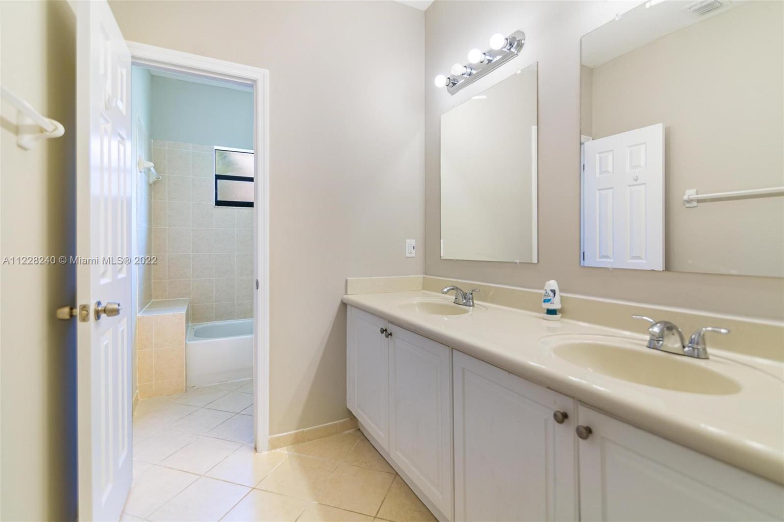11451 Southwest 243 Terrace Homestead, FL 33032 - Photo 24 of 49 a bathroom with a double vanity sink and mirror with shower