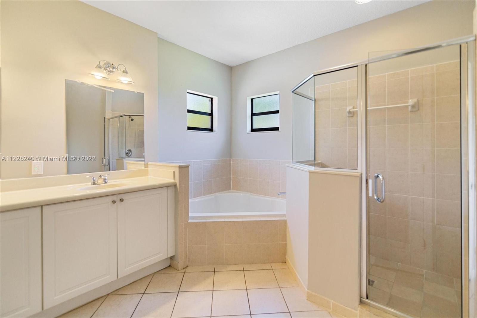 11451 Southwest 243 Terrace Homestead, FL 33032 - Photo 31 of 49 a bathroom with a sink a shower a mirror and a bathtub
