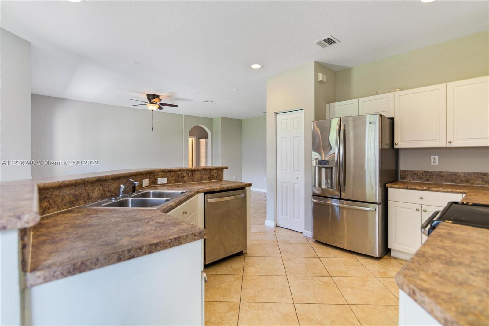 11451 Southwest 243 Terrace Homestead, FL 33032 - Photo 7 of 49 a kitchen with stainless steel appliances granite countertop a sink and a refrigerator