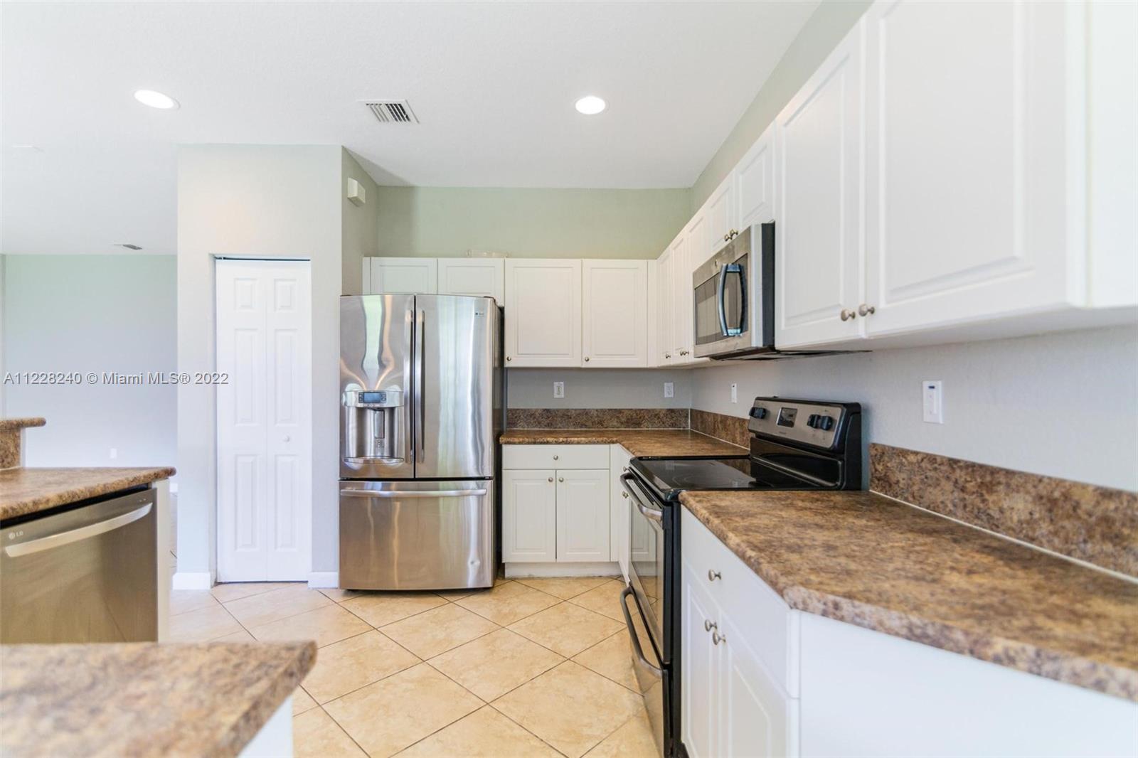 11451 Southwest 243 Terrace Homestead, FL 33032 - Photo 8 of 49 a kitchen with a refrigerator sink and cabinets