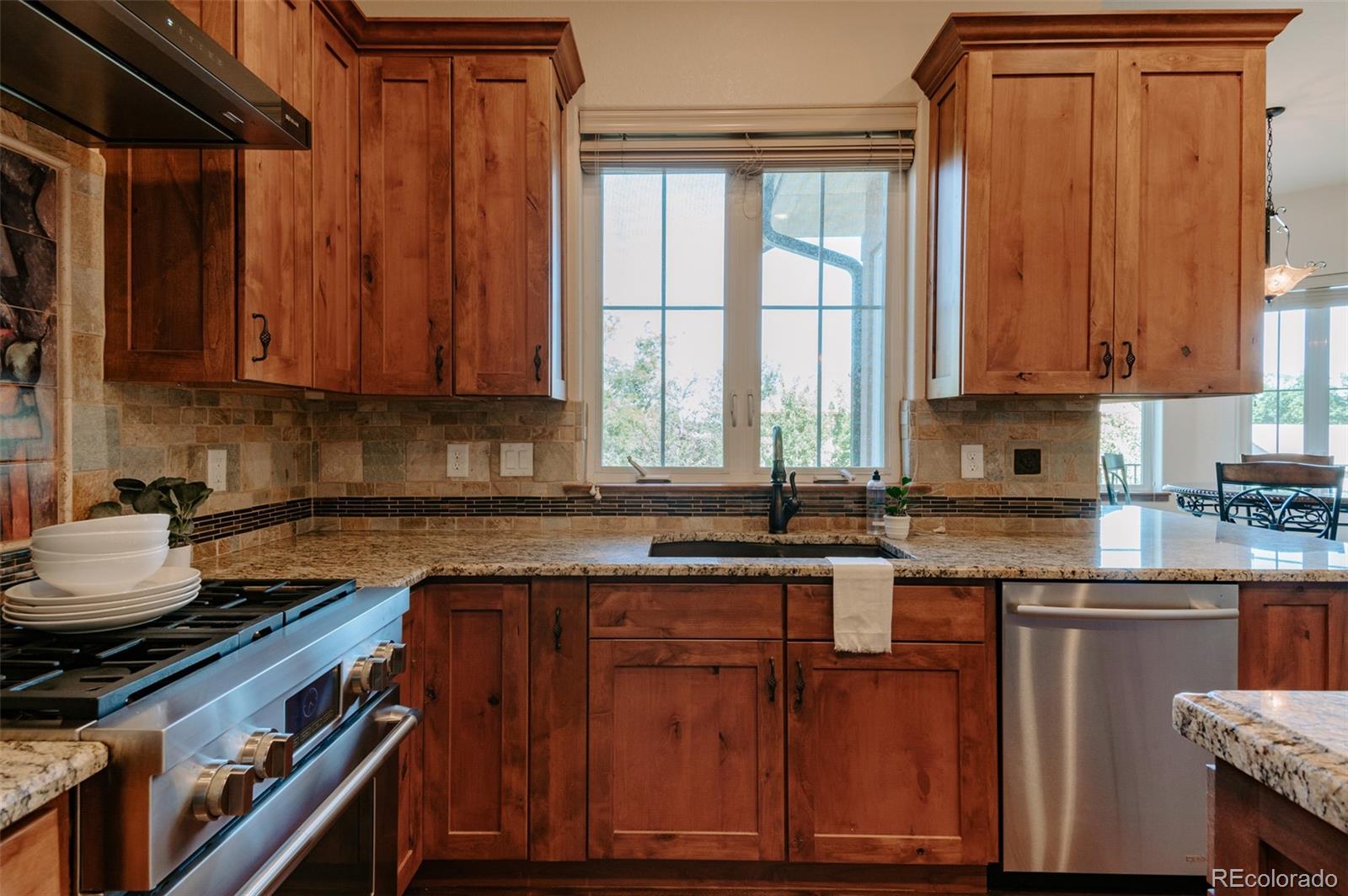 5792 Yank Street Arvada, CO 80002 - Photo 11 of 40 a kitchen with wooden cabinets and a sink