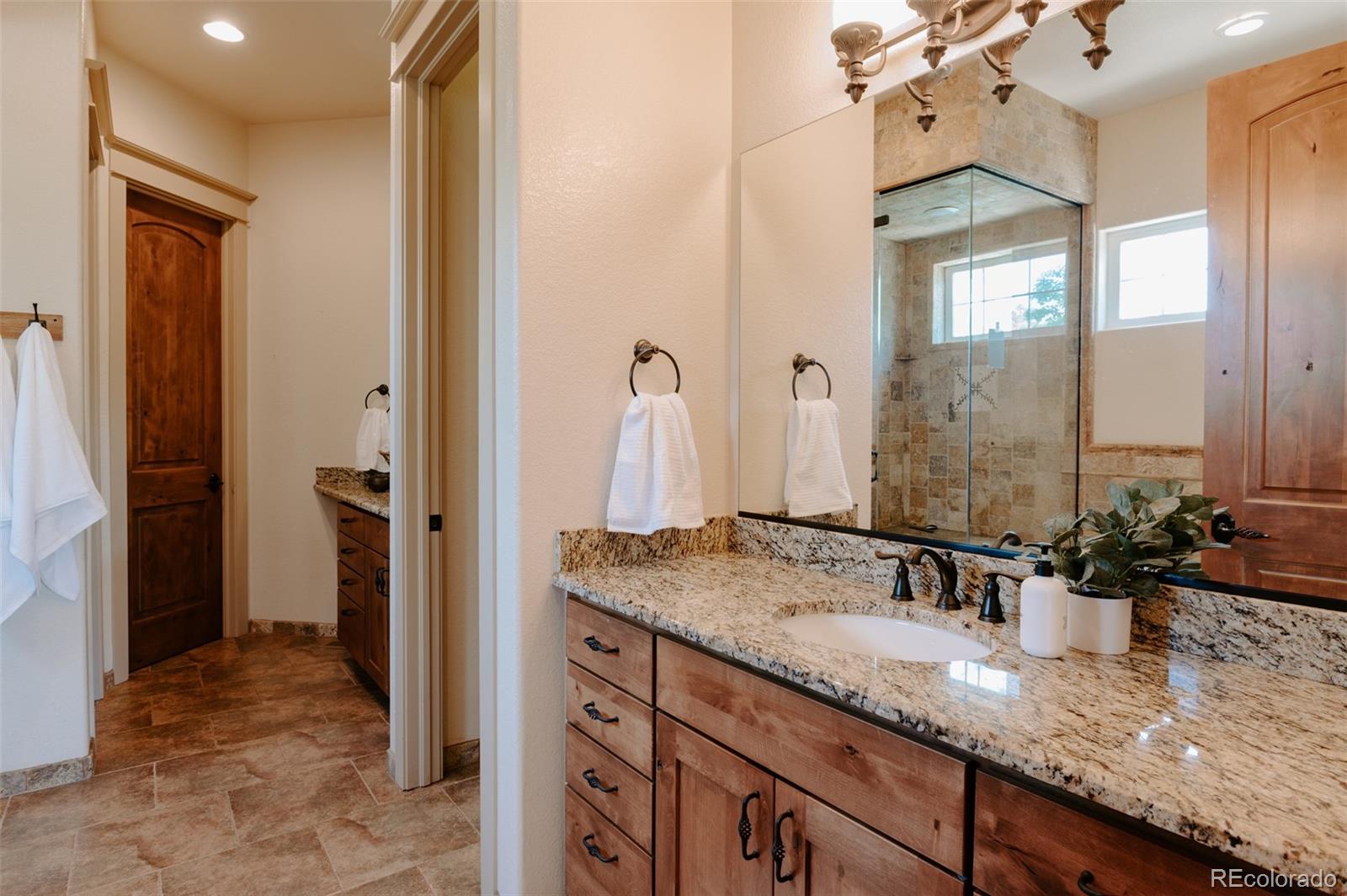 5792 Yank Street Arvada, CO 80002 - Photo 18 of 40 a bathroom with a granite countertop sink and a mirror