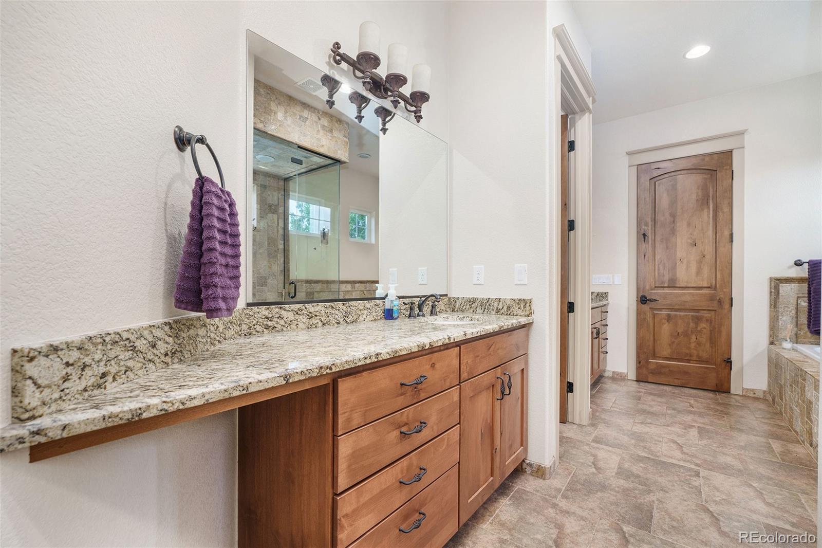 5792 Yank Street Arvada, CO 80002 - Photo 19 of 40 a bathroom with a granite countertop sink and a mirror