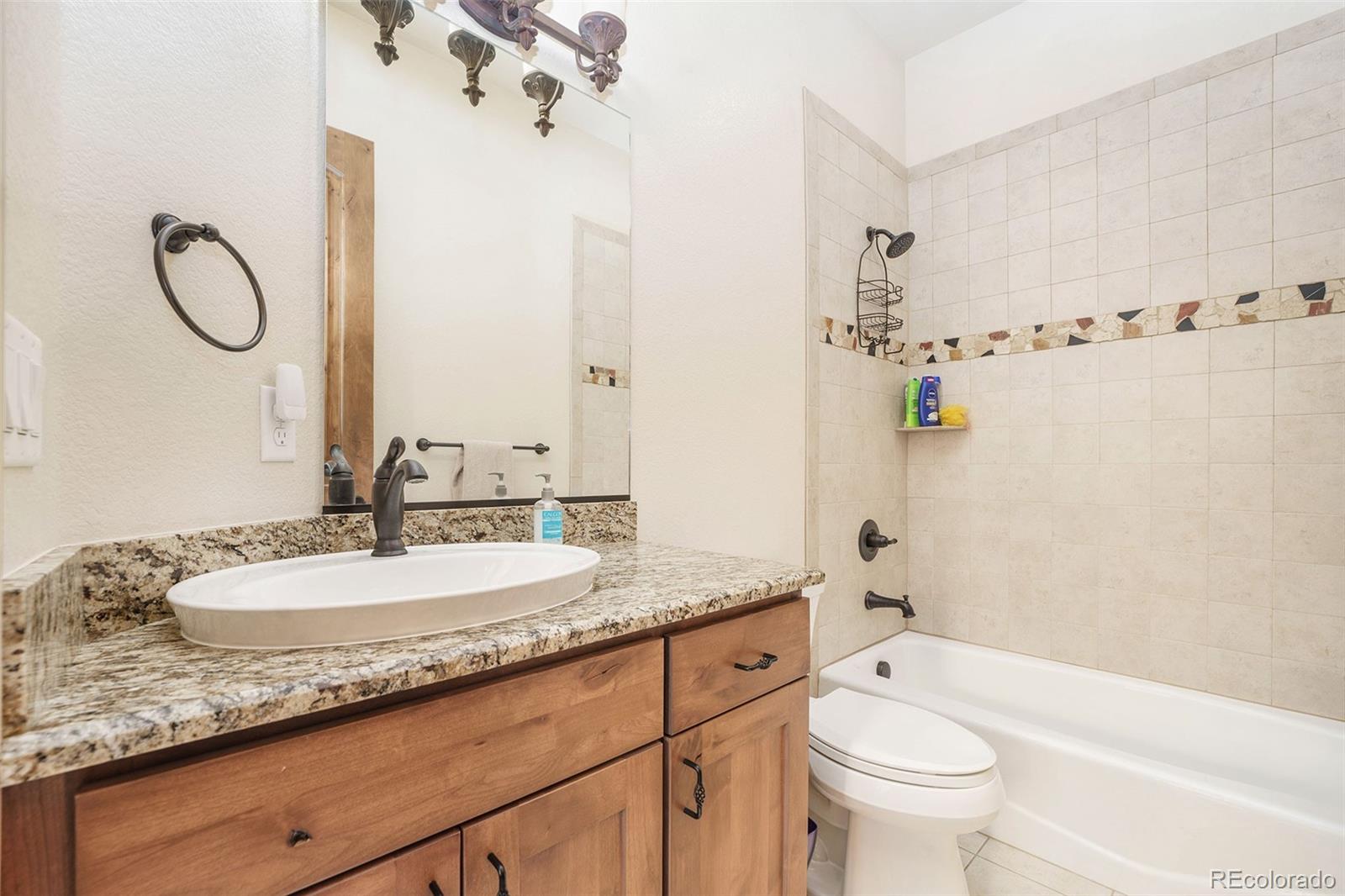 5792 Yank Street Arvada, CO 80002 - Photo 22 of 40 a bathroom with a granite countertop sink mirror toilet and bathtub