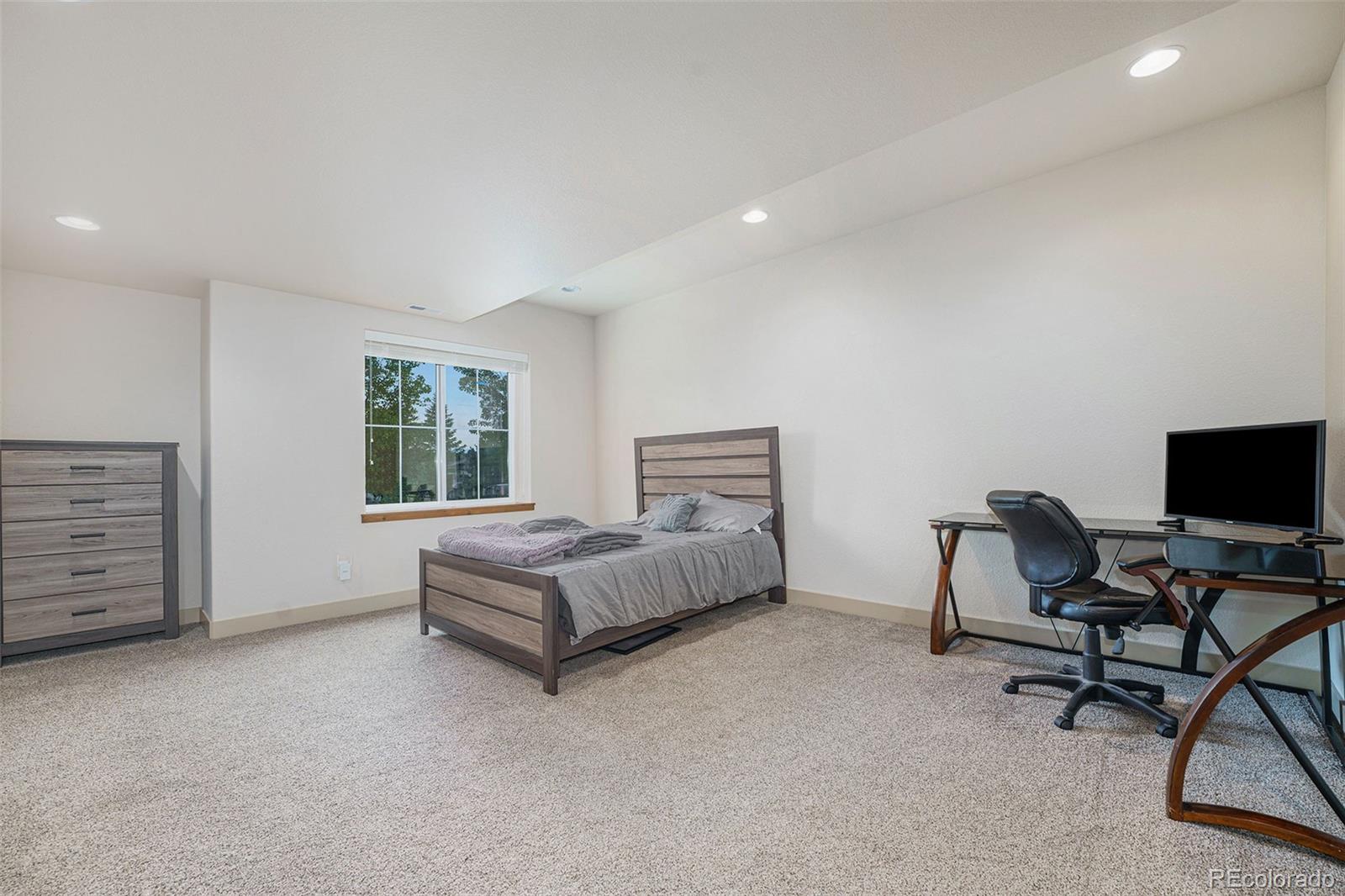 5792 Yank Street Arvada, CO 80002 - Photo 33 of 40 a bedroom with a bed and a chair