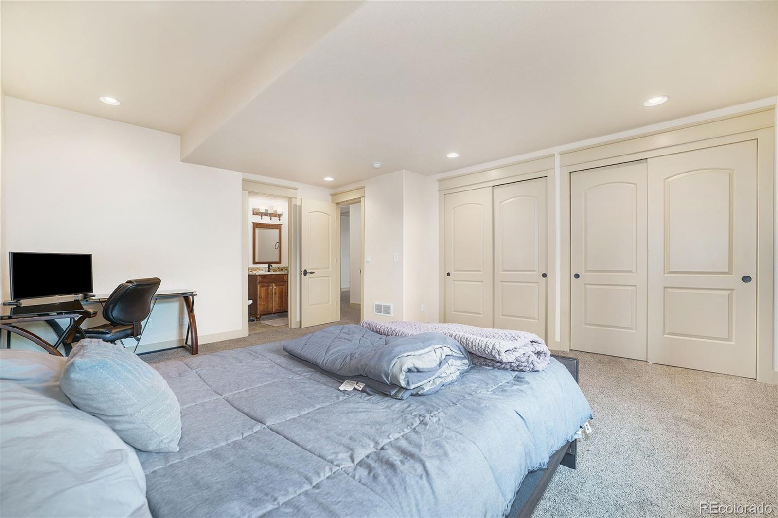 5792 Yank Street Arvada, CO 80002 - Photo 34 of 40 a spacious bedroom with a bed and furniture