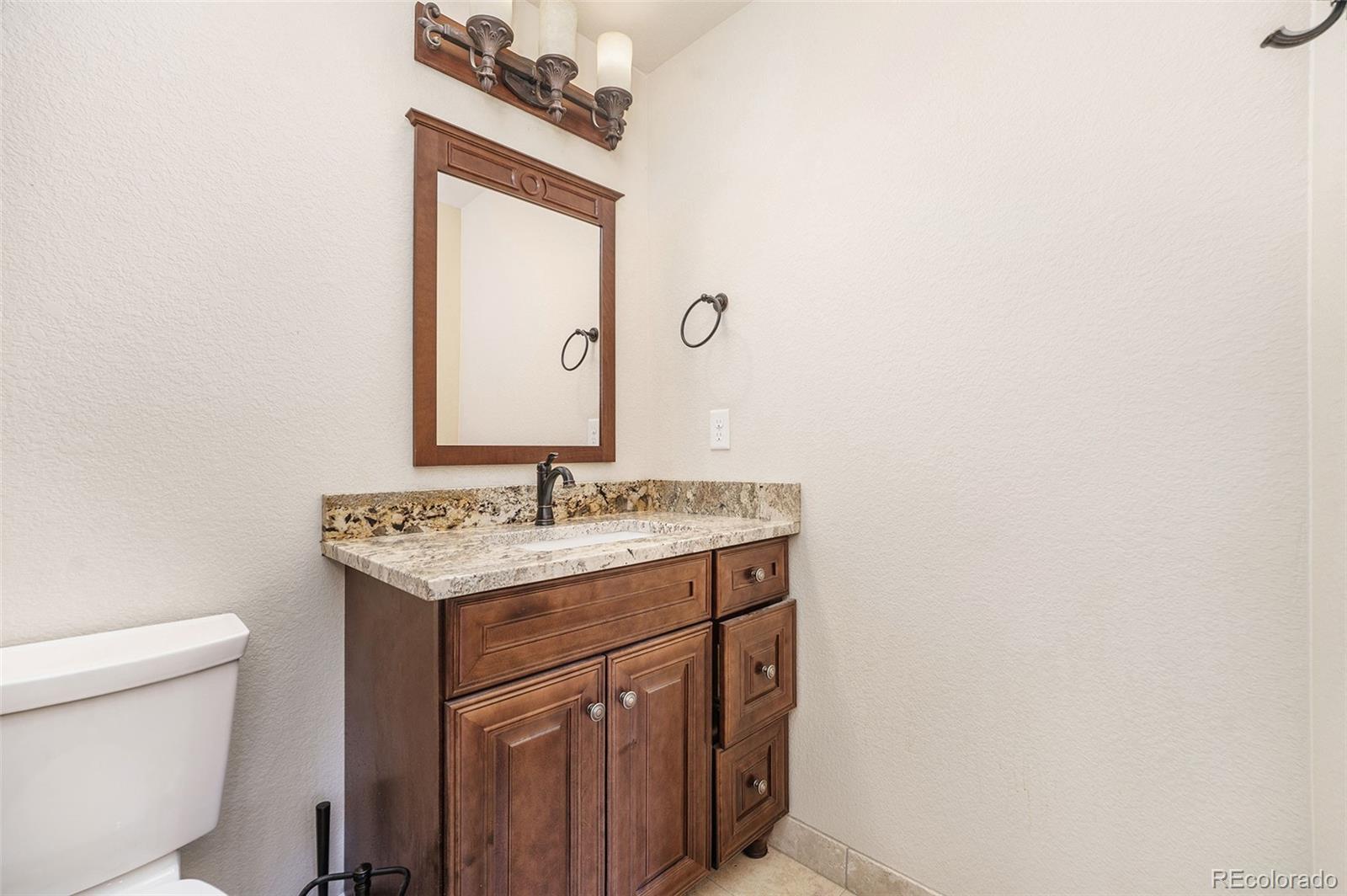 5792 Yank Street Arvada, CO 80002 - Photo 35 of 40 a bathroom with a sink a toilet and mirror