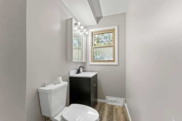 a bathroom with a toilet a sink and a window
