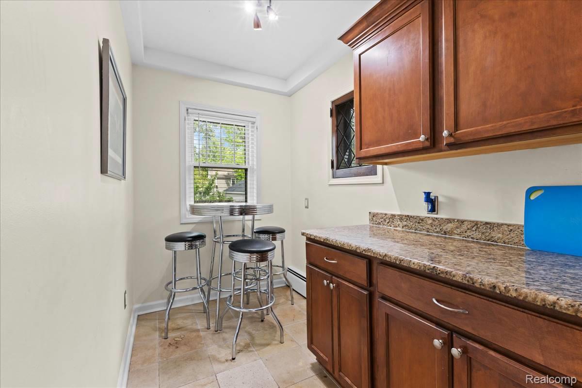 43 Wellesley Drive Pleasant Ridge, MI 48069 - Photo 11 of 52 Wood-finish cabinetry paired with a speckled countertop, tile flooring, and a single window with blinds