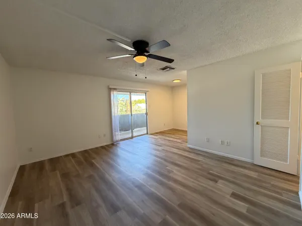 an empty room with wooden floor and windows