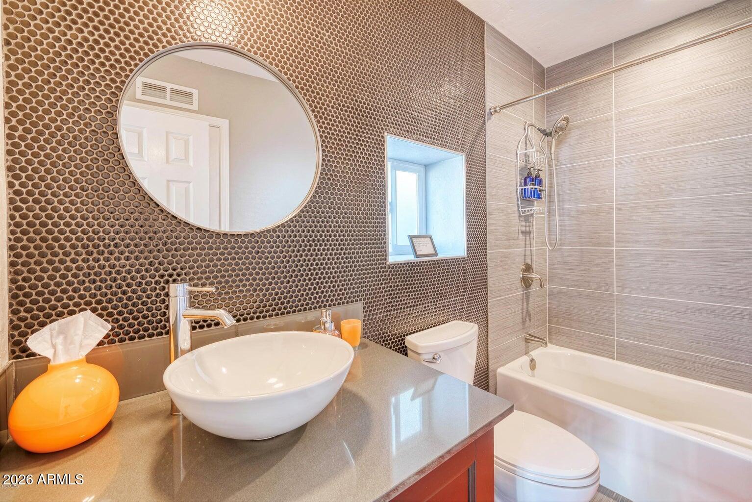 3415 East Camelback Road Phoenix, AZ 85018 - Photo 20 of 25 a bathroom with a toilet sink vanity granite tub and mirror
