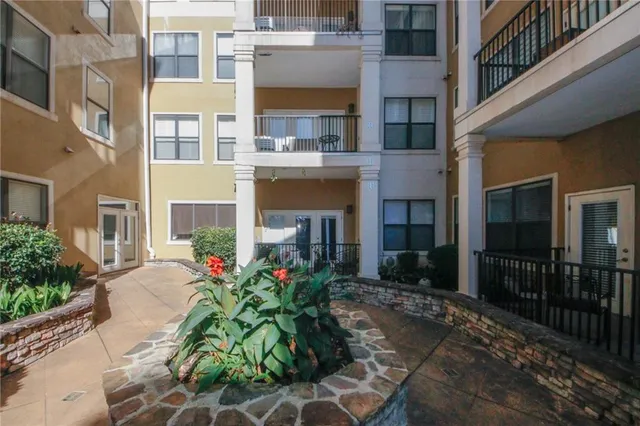 a front view of a building with a flower garden