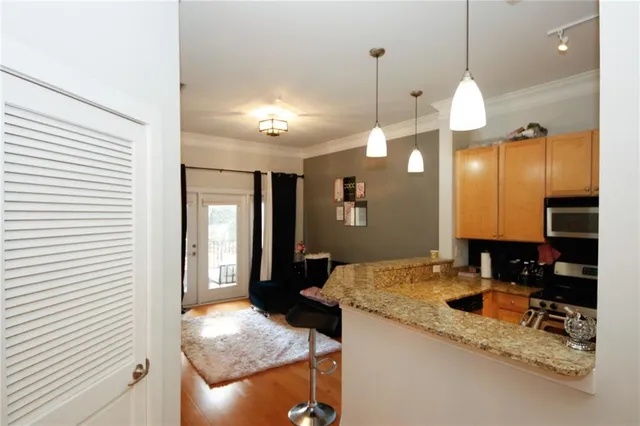 a kitchen with granite countertop a sink a counter top space and cabinets