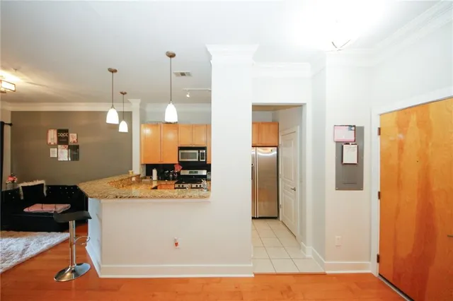 a view of a kitchen with kitchen island a counter top space and stainless steel appliances