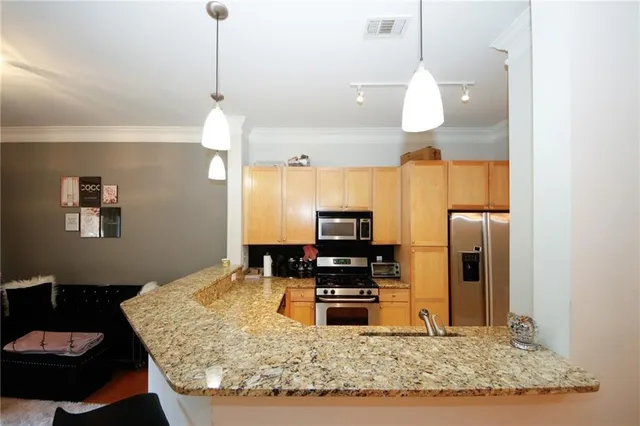 a kitchen with stainless steel appliances kitchen island granite countertop a refrigerator a stove and a sink
