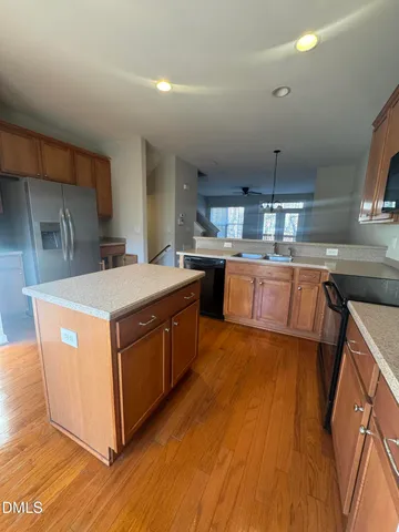 a kitchen with stainless steel appliances granite countertop a sink a stove and a wooden floors