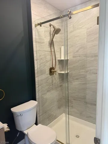 a white toilet sitting next to a shower