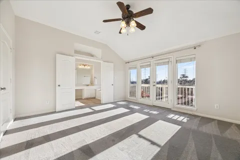 an empty room with windows and ceiling fan