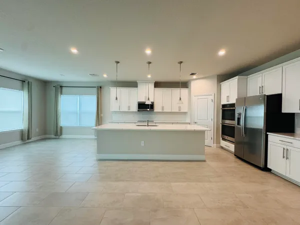 a kitchen with white cabinets and sink