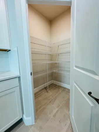 a kitchen with a refrigerator and white cabinets