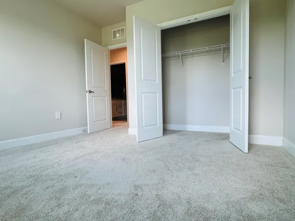 an empty room with windows and closet