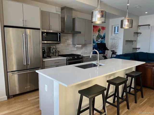 a kitchen with stainless steel appliances a microwave sink and refrigerator