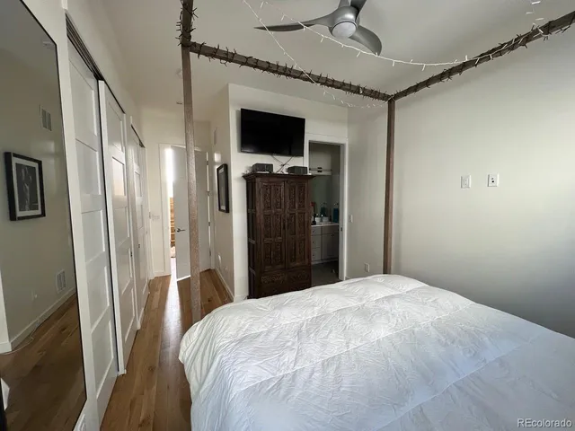 a bedroom with a large bed and a flat tv screen