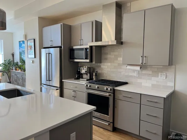 a kitchen with cabinets appliances a sink and a counter top space