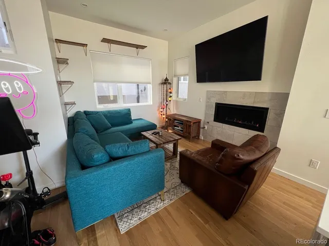 a living room with furniture a flat screen tv and a fireplace