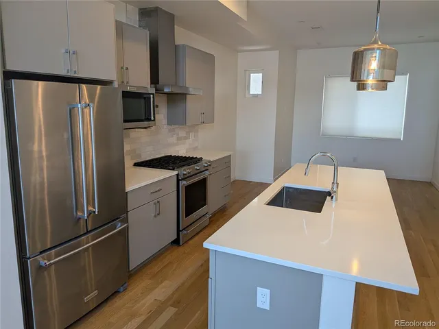a kitchen with stainless steel appliances a refrigerator sink and microwave