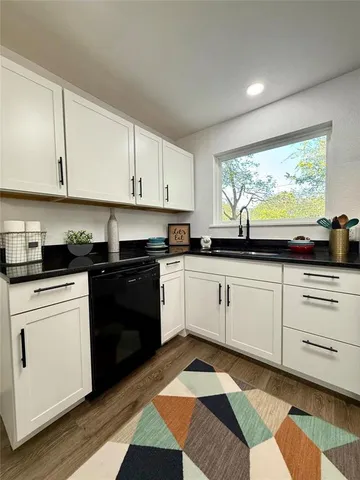 a kitchen with granite countertop white cabinets and appliances