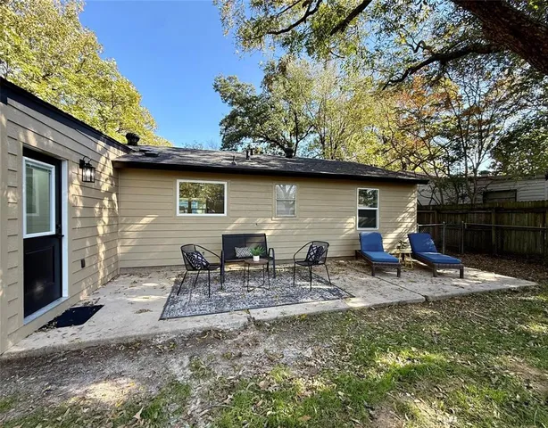 a view of a patio with table and chairs under an umbrella