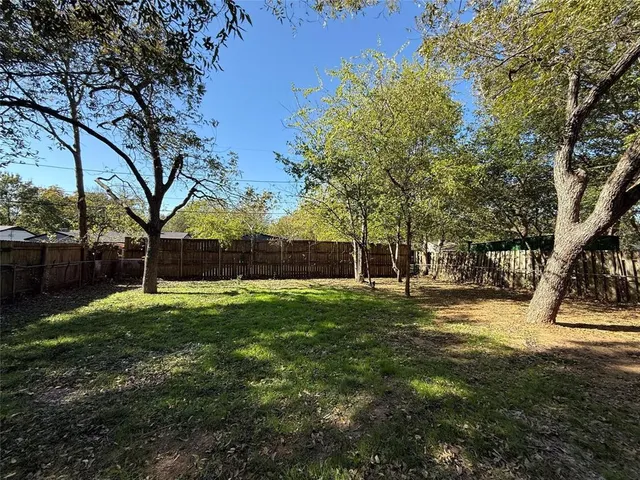 a view of a backyard with large trees