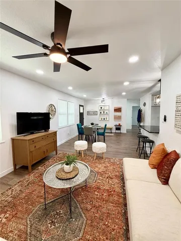 a living room with furniture a flat screen tv and kitchen view