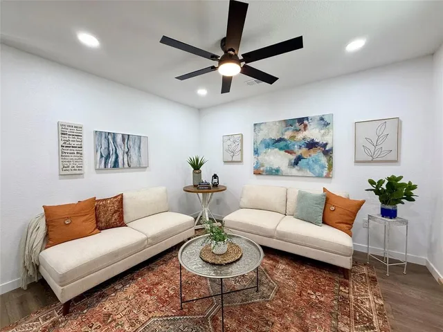 a living room with furniture and a wooden floor