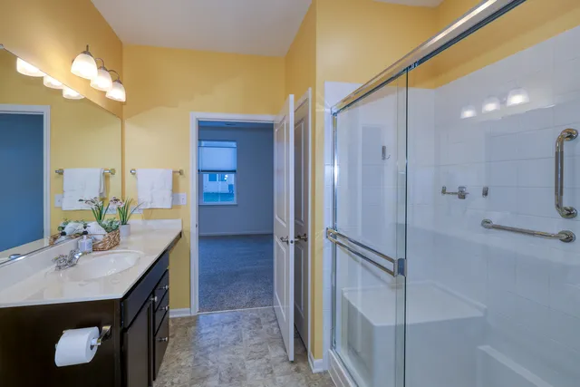 a bathroom with a double vanity sink mirror and shower