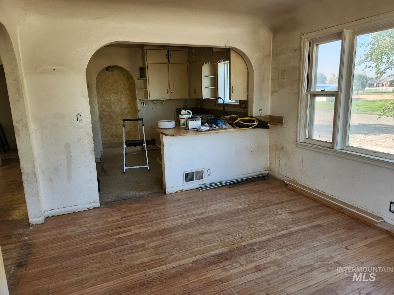 525 North 4th Street Nyssa, OR 97913 - Photo 5 of 17 Kitchen with light wood-style floors, open shelves, a peninsula, arched walkways, and light countertops