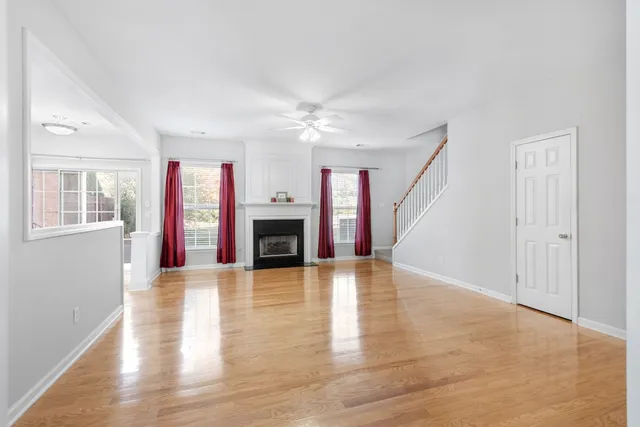wooden floor fireplace and windows in an empty room