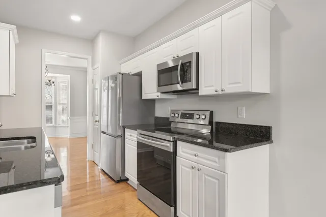 a kitchen with stainless steel appliances granite countertop a stove a microwave and a refrigerator