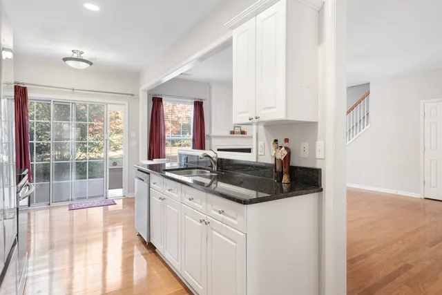a kitchen with stainless steel appliances granite countertop a stove a sink and a granite counter tops with white cabinets