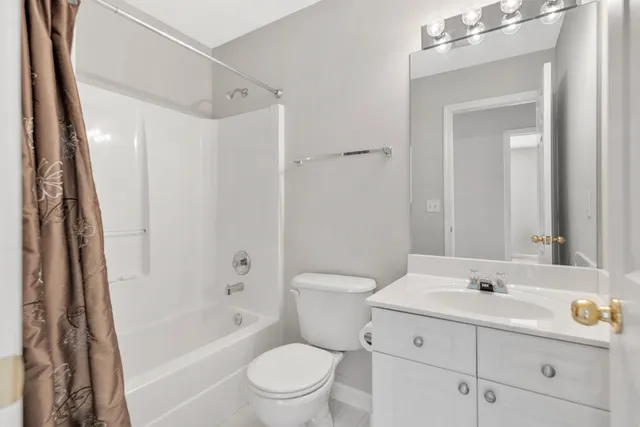 a bathroom with a sink a toilet a mirror a vanity and shower