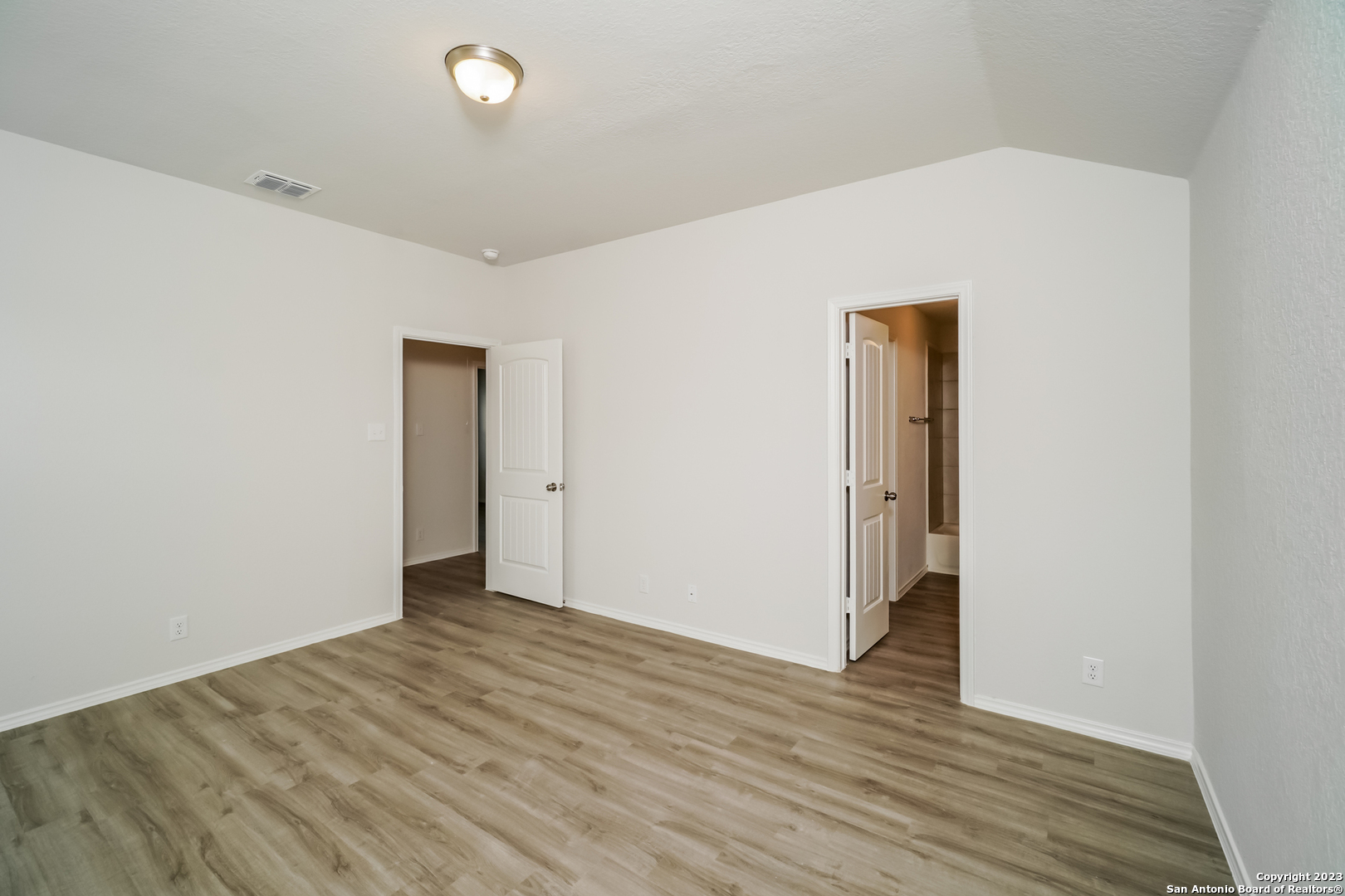 9318 Evening Shade Court San Antonio, TX 78211 - Photo 9 of 15 a view of an empty room with wooden floor and a window